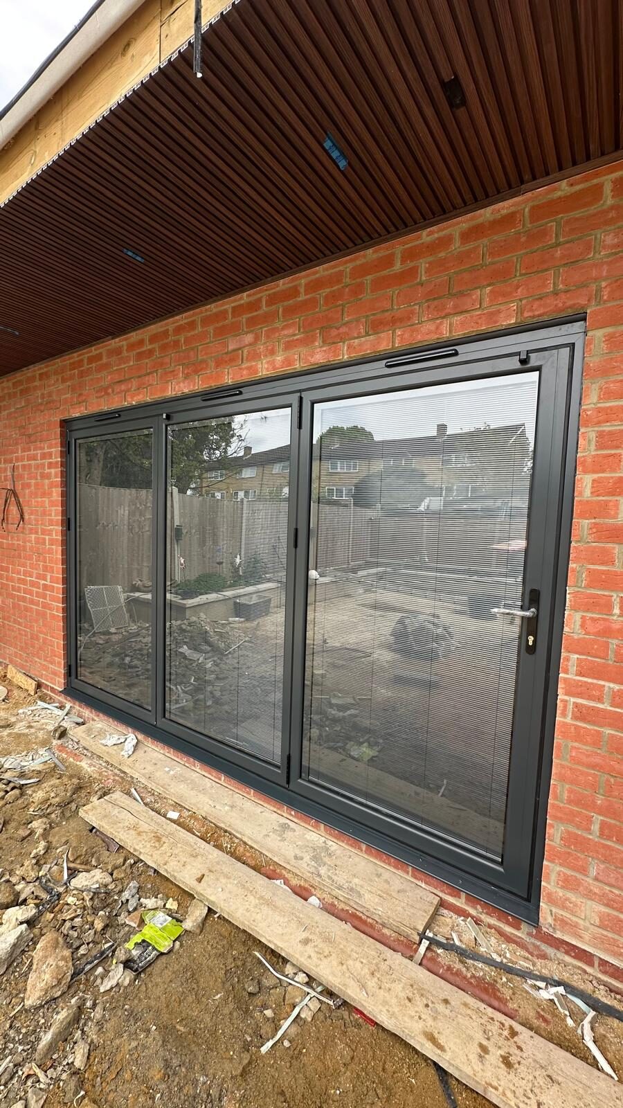 Three-panel anthracite aluminium bifolding doors with integral blinds